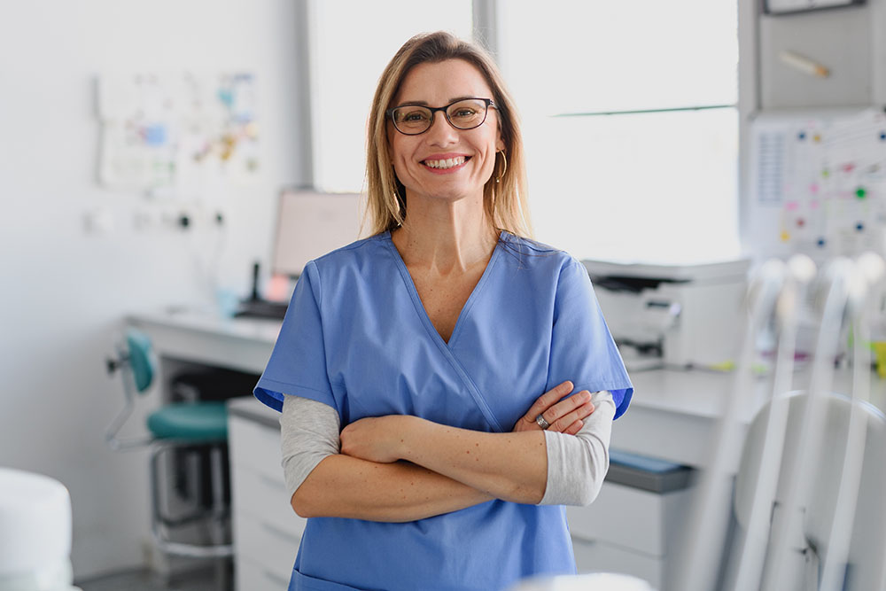 Smiling female nurse standing confidently in a modern medical clinic.