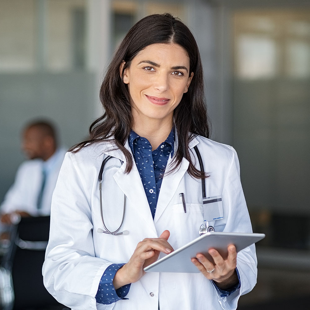 Portrait of beautiful mature woman doctor holding digital tablet and looking at camera.